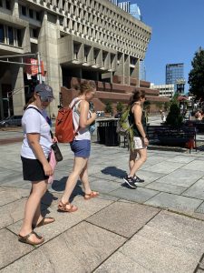 Three adults walking along flagstones in downtown Boston.