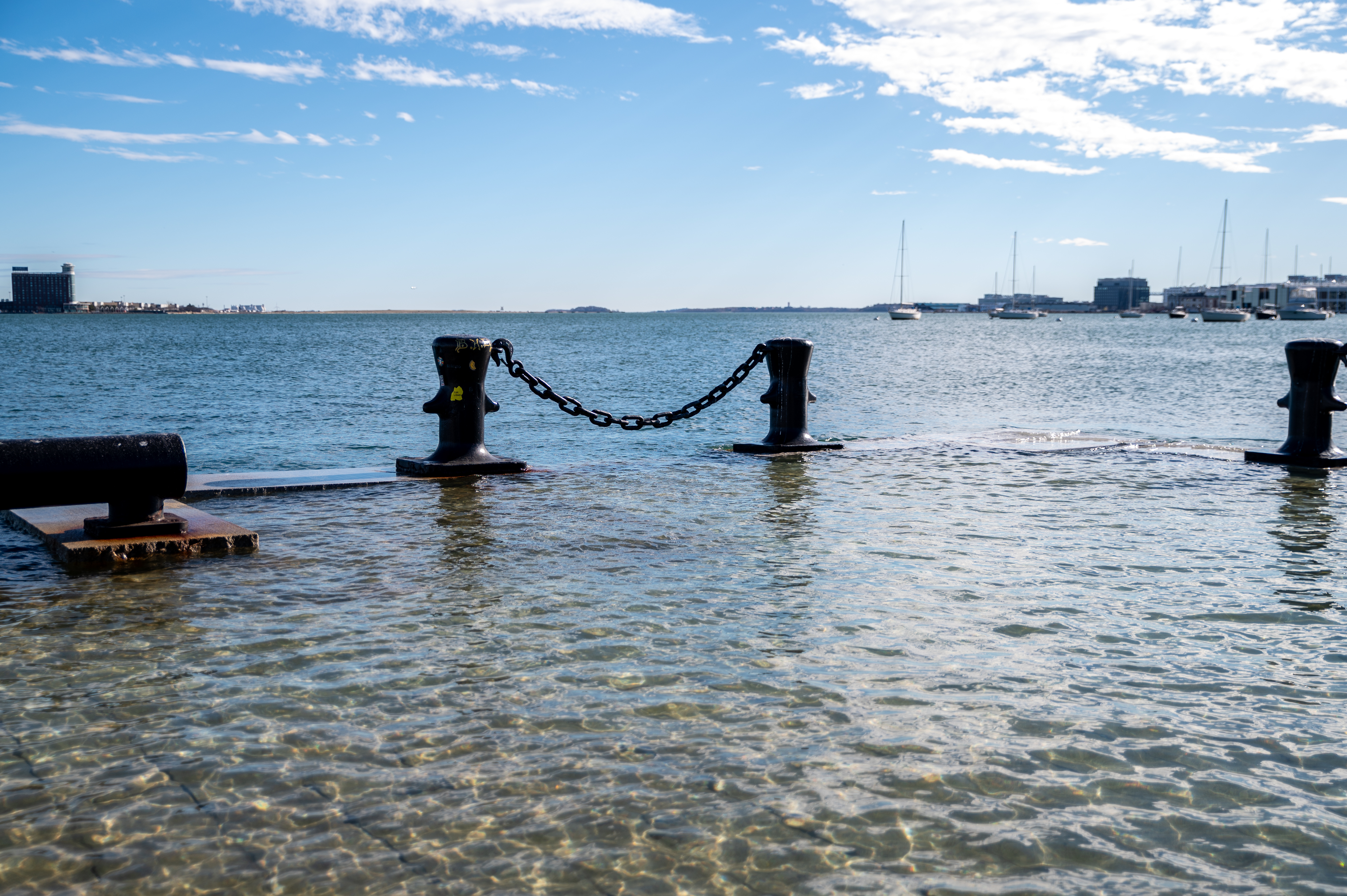 A flooded wharf, with the open harbor in the background