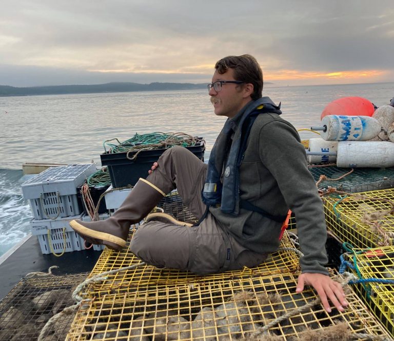 Curtis sitting on a boat in the ocean.